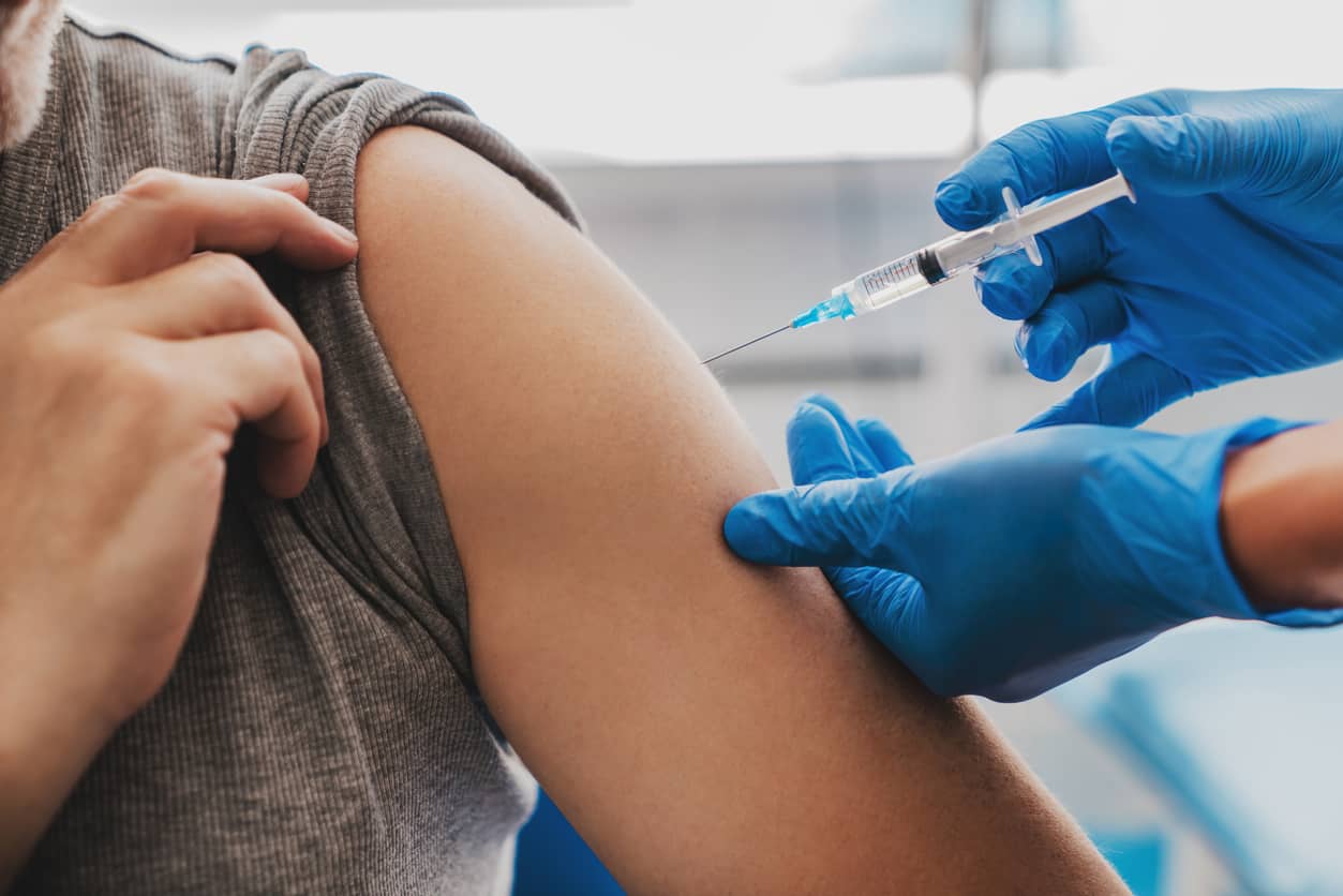 Aplicação de vacina no braço de um adulto