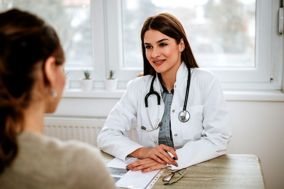 Médica sorrindo durante consulta com paciente